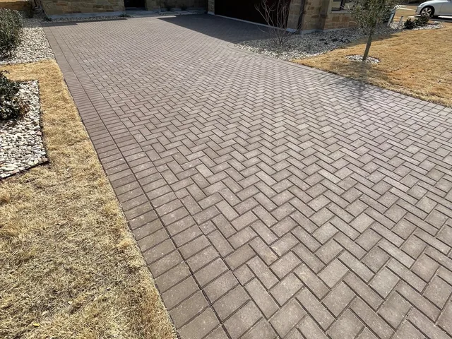 A herringbone paver driveway running to a garage